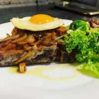 300 g vepřová kotleta (s kostí) s cibulovou krustou, bylinkami a sázeným vejcem (3,7)
